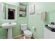 Cozy powder room with a pedestal sink, toilet, and decorative mirror, enhanced with a fresh coat of light green paint at 18542 W Valerie Dr, Surprise, AZ 85374