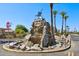 Community entrance with rock waterfall, palm trees, and well-manicured landscaping at 2055 N 56Th St # 15, Mesa, AZ 85215