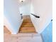 Wooden staircase with contrasting railing leads down to light hardwood flooring and carpet at 225 N Standage -- # 45, Mesa, AZ 85201