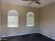 Bare bedroom with neutral walls, ceiling fan, and arched windows with blinds at 23317 N Arrellaga Dr, Sun City West, AZ 85375