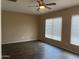 Bedroom with wood-look tile flooring, two windows, and a ceiling fan at 23317 N Arrellaga Dr, Sun City West, AZ 85375