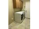 Bright laundry room with a washer and dryer, tile floor, and overhead cabinet at 23317 N Arrellaga Dr, Sun City West, AZ 85375