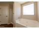 Bright bathroom featuring a soaking tub and a separate shower with wood-look flooring at 33055 N Madison Way Dr, San Tan Valley, AZ 85144