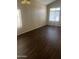 A cozy bedroom features two sunny windows, dark wood floors, and neutral paint at 33055 N Madison Way Dr, San Tan Valley, AZ 85144