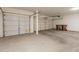 Spacious three car garage with white doors, overhead lighting, and concrete flooring at 33055 N Madison Way Dr, San Tan Valley, AZ 85144