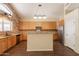 Well-lit kitchen with stone accent wall, wooden cabinets, stainless steel appliances, and breakfast bar at 33055 N Madison Way Dr, San Tan Valley, AZ 85144