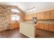 Well-lit kitchen with stone accent wall, lots of wooden cabinets, and breakfast bar at 33055 N Madison Way Dr, San Tan Valley, AZ 85144
