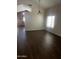 Bright living room boasts wood floors, chandelier, and abundant natural light from a large window at 33055 N Madison Way Dr, San Tan Valley, AZ 85144