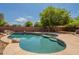 Freeform pool with rock features, flagstone coping, and clear blue water surrounded by lush greenery at 33055 N Madison Way Dr, San Tan Valley, AZ 85144