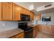 The kitchen boasts wooden cabinetry, granite countertops, and black appliances at 3600 N 5Th Ave # 302, Phoenix, AZ 85013