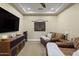 Cozy media room with comfortable leather seating, ceiling fan and wall-mounted speakers at 36389 N 105Th Pl, Scottsdale, AZ 85262
