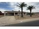 Single story home featuring a covered parking area, desert landscaping, and two palm trees at 3749 W Gelding Dr, Phoenix, AZ 85053