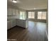 View of the kitchen featuring white cabinetry, laminate countertops and modern flooring at 3749 W Gelding Dr, Phoenix, AZ 85053
