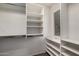 Walk-in closet with white shelving units and ample storage space by a window at 40345 W Molly Ln, Maricopa, AZ 85138
