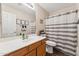Bathroom features a single sink vanity, with a toilet and a shower with a striped curtain at 4314 E Anderson Dr, Phoenix, AZ 85032