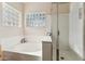 Bright bathroom featuring a soaking tub with a glass block window, and a separate shower at 4314 E Anderson Dr, Phoenix, AZ 85032