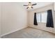 Neutral bedroom features carpet flooring, a ceiling fan, and a window with black curtains at 4314 E Anderson Dr, Phoenix, AZ 85032