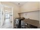 Laundry room area showcases modern washer and dryer, a shelf, and tile flooring at 4314 E Anderson Dr, Phoenix, AZ 85032