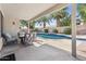 Relaxing covered patio area overlooks a sparkling pool and lush palm trees at 4314 E Anderson Dr, Phoenix, AZ 85032