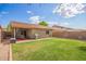 Spacious backyard with green grass, covered patio, barbecue, and desert landscaping at 44976 W Miramar Rd, Maricopa, AZ 85139