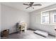 Bright bedroom with a ceiling fan, window, desk, chair, and soft carpet at 44976 W Miramar Rd, Maricopa, AZ 85139