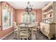 Charming dining room featuring a round table, floral chairs, and natural light from shuttered windows at 44976 W Miramar Rd, Maricopa, AZ 85139