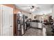 Updated kitchen with stainless steel appliances, gray cabinets, and open layout to the living room at 44976 W Miramar Rd, Maricopa, AZ 85139