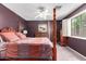 Spacious main bedroom with a four-poster bed, soft carpet, dresser, and bright window at 44976 W Miramar Rd, Maricopa, AZ 85139