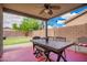 Relaxing covered patio with fan, stylish furniture, and brick flooring overlooking a grassy backyard at 44976 W Miramar Rd, Maricopa, AZ 85139