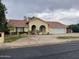Charming single-story home featuring an arched entryway, desert landscaping, and a spacious two-car garage at 4801 E Sheena Dr, Scottsdale, AZ 85254