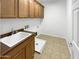 Laundry room featuring sink, cabinet space, and tile flooring at 5140 W Bent Tree Dr, Phoenix, AZ 85083