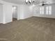 Spacious carpeted living room with white walls and ample natural light showcases a welcoming atmosphere at 5140 W Bent Tree Dr, Phoenix, AZ 85083