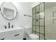 Contemporary bathroom featuring sleek fixtures, glass shower door, black framed mirror, and bright white tiling at 6302 N 13Th Pl, Phoenix, AZ 85014