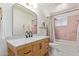 Bathroom features a wooden vanity with marble countertop and a shower with pink tile, offering a charming, renovated space at 6302 N 13Th Pl, Phoenix, AZ 85014