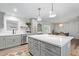 Bright, updated kitchen features an island with white countertop, gray cabinets with gold hardware, and stainless steel appliances at 6302 N 13Th Pl, Phoenix, AZ 85014