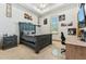 Stylish bedroom features a wooden bed frame, tray ceiling, and a comfortable workspace at 7482 S Mccormick Way, Queen Creek, AZ 85142