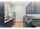 Convenient laundry room featuring stainless steel appliances, ample cabinet space, and natural light at 7482 S Mccormick Way, Queen Creek, AZ 85142
