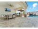 Outdoor kitchen and dining area overlooking the backyard pool and waterfall at 7482 S Mccormick Way, Queen Creek, AZ 85142