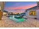 Luxury pool with built-in spa and lounge area, decorative fountains, lush landscaping, and travertine tile deck at 7482 S Mccormick Way, Queen Creek, AZ 85142
