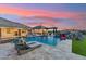 Lush backyard with a resort-style pool, rock waterfall, and outdoor kitchen area at 7482 S Mccormick Way, Queen Creek, AZ 85142