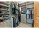 This walk-in closet features custom shelves and rods for organizing clothing and accessories at 7482 S Mccormick Way, Queen Creek, AZ 85142