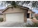 Home featuring an attached two-car garage, desert landscaping, and a covered entryway at 7771 N 58Th Ln, Glendale, AZ 85301