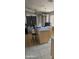 A kitchen featuring an island, chandelier, neutral tile flooring, and an adjacent living space, though cluttered with items at 7771 N 58Th Ln, Glendale, AZ 85301