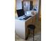 Kitchen island with a light countertop, stool, and workspace accessories, needing decluttering at 7771 N 58Th Ln, Glendale, AZ 85301