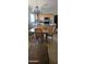 Kitchen featuring wood cabinets, a kitchen table with chairs, and tile floors, though the space needs decluttering at 7771 N 58Th Ln, Glendale, AZ 85301