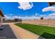 Spacious backyard featuring artificial grass, gravel accents, trampoline, and a block wall for added privacy at 858 W Knowles Cir, Mesa, AZ 85210