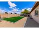 Spacious backyard with artificial turf, gravel landscaping, and a brick perimeter fence at 858 W Knowles Cir, Mesa, AZ 85210
