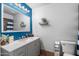 Bright bathroom features a large mirror, modern vanity, and contrasting blue accent wall at 858 W Knowles Cir, Mesa, AZ 85210