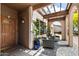 Warm, covered entryway with tiled flooring, comfortable seating, and charming arched supports at 858 W Knowles Cir, Mesa, AZ 85210