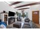 Bright living room featuring beamed ceilings, tiled floors, a cozy fireplace, and a large window at 858 W Knowles Cir, Mesa, AZ 85210